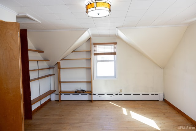 bonus room with wood-type flooring and a baseboard radiator