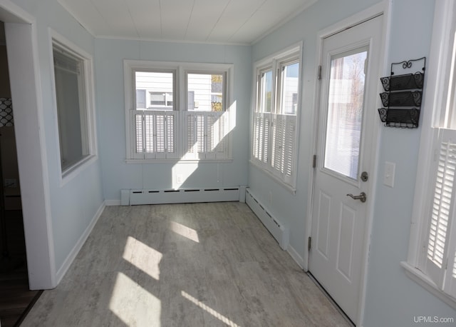 doorway featuring light wood-type flooring, baseboard heating, and crown molding