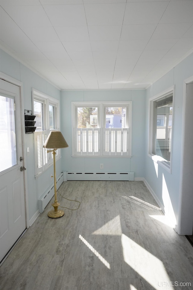 interior space featuring baseboard heating and light hardwood / wood-style floors