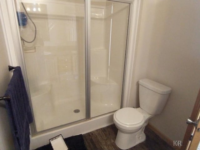 bathroom with wood-type flooring, an enclosed shower, and toilet