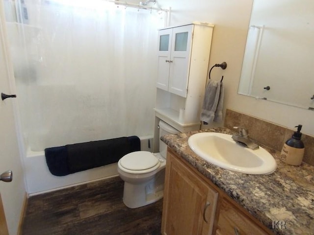 bathroom featuring wood-type flooring, vanity, toilet, and curtained shower