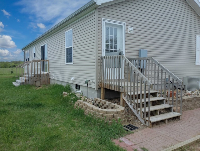 view of side of property featuring cooling unit and a yard