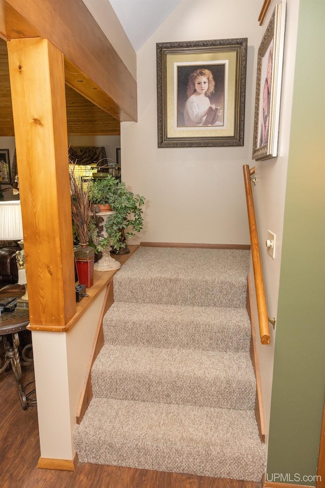 stairway with lofted ceiling and hardwood / wood-style floors