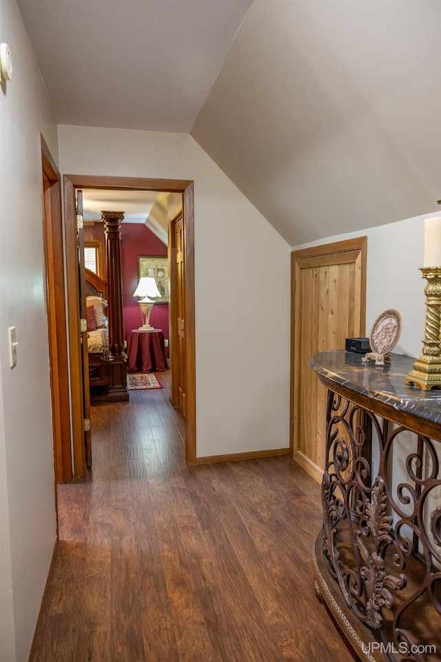 hall featuring lofted ceiling and dark hardwood / wood-style flooring