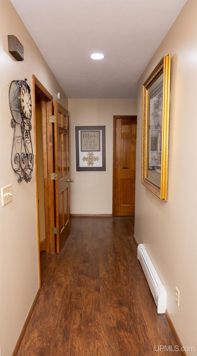 corridor featuring dark hardwood / wood-style flooring and a baseboard radiator