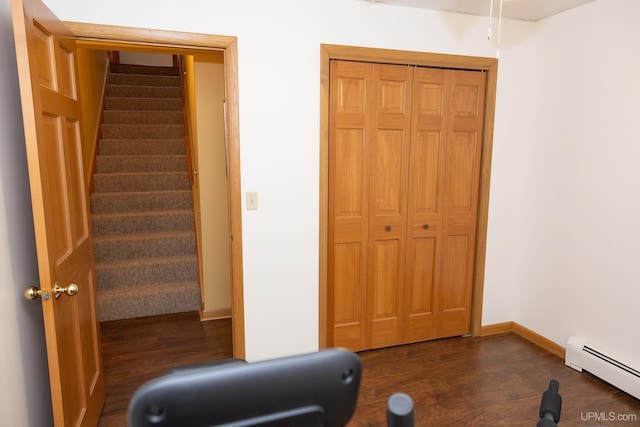 exercise area featuring dark hardwood / wood-style flooring and a baseboard radiator