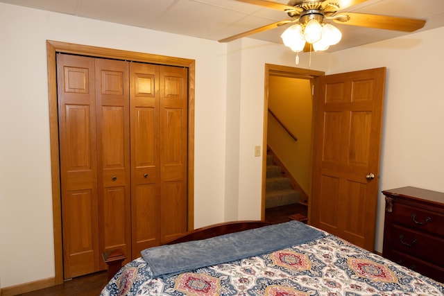 bedroom with ceiling fan, a closet, and dark wood-type flooring