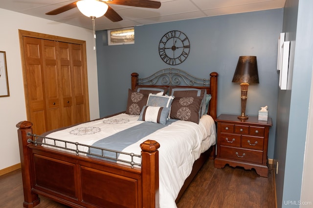 bedroom with a closet, dark hardwood / wood-style floors, and ceiling fan