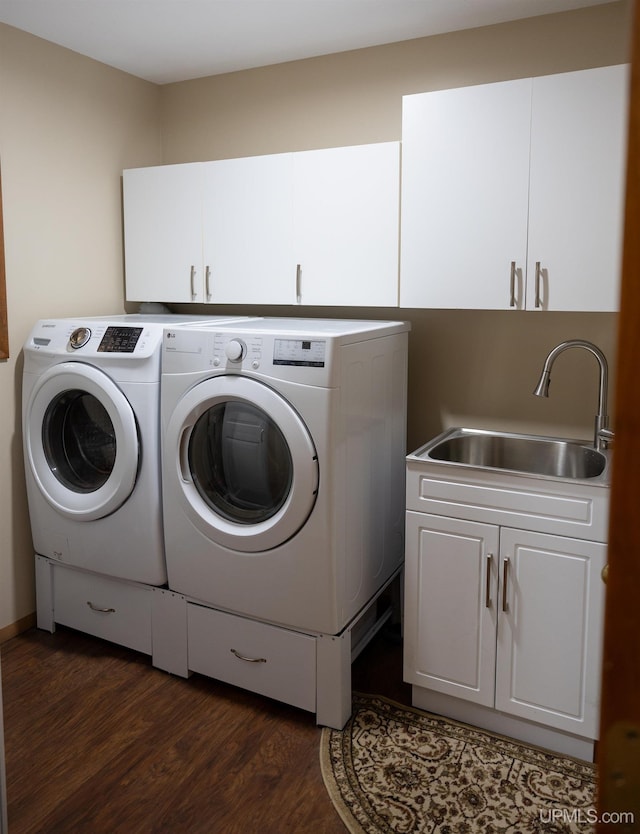 clothes washing area featuring sink, independent washer and dryer, dark wood-type flooring, and cabinets