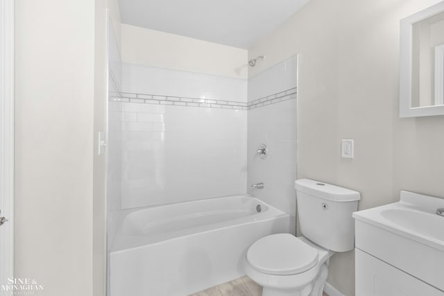 full bathroom featuring tiled shower / bath combo, vanity, and toilet