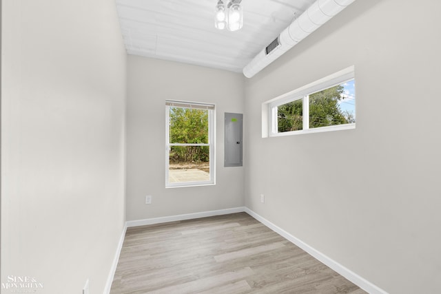 empty room featuring electric panel and light wood-type flooring