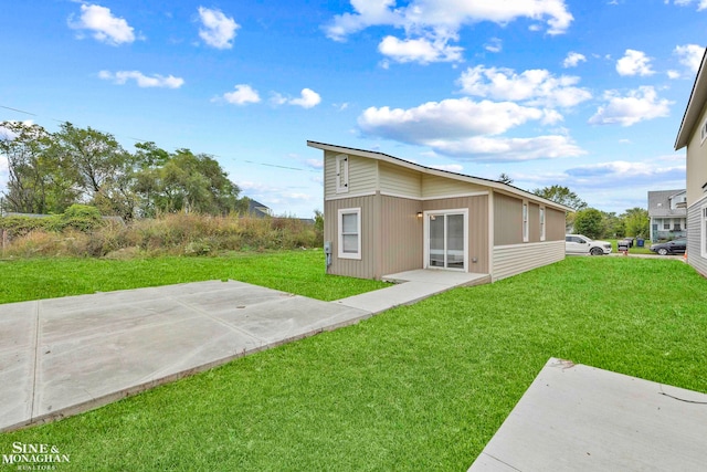 back of property with a patio and a lawn