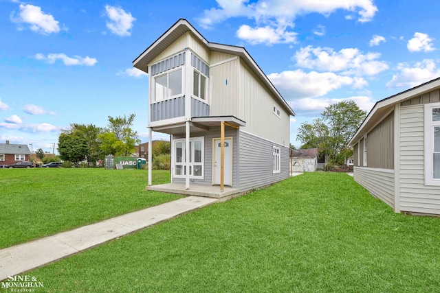 back of property with a yard and a sunroom