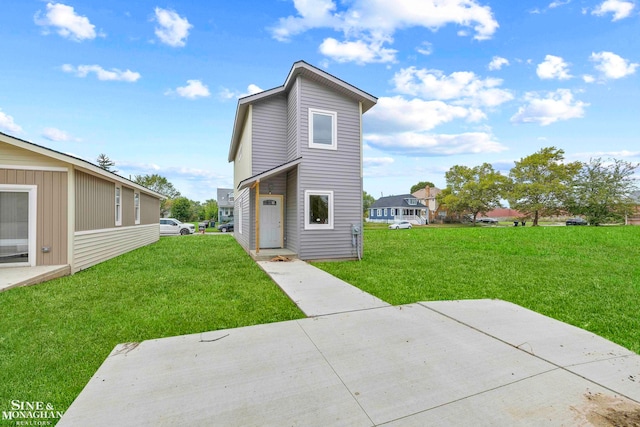 back of property with a lawn and a patio