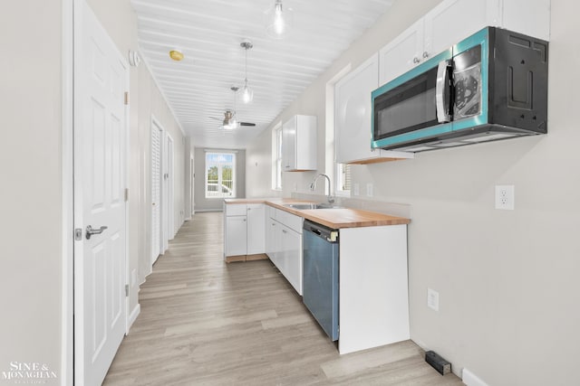 kitchen featuring pendant lighting, sink, wooden counters, white cabinetry, and appliances with stainless steel finishes