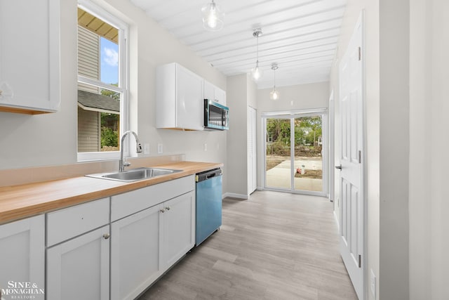 kitchen featuring white cabinets, sink, decorative light fixtures, stainless steel appliances, and wood counters