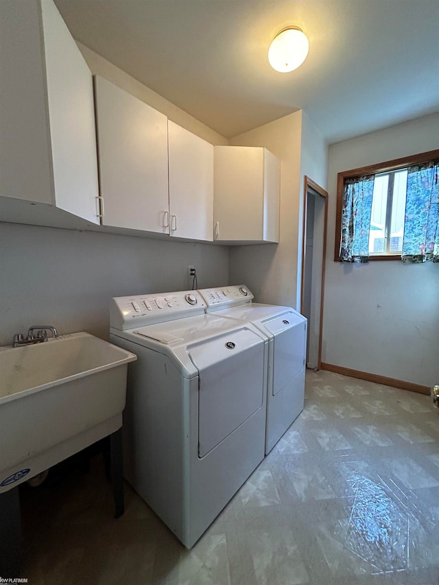 washroom featuring washer and dryer, sink, and cabinets