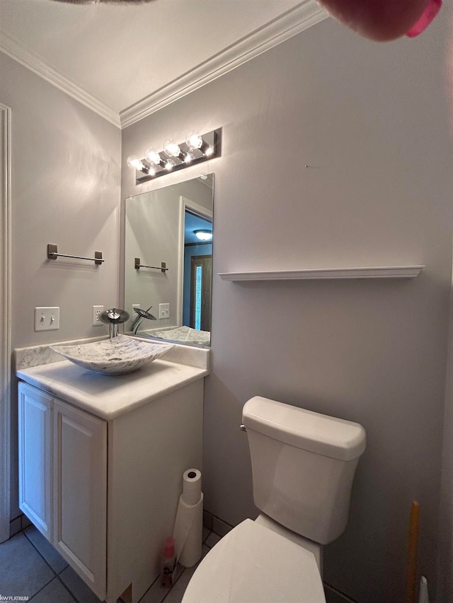 bathroom with tile patterned flooring, ornamental molding, vanity, and toilet