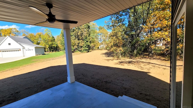 view of yard featuring ceiling fan and a garage