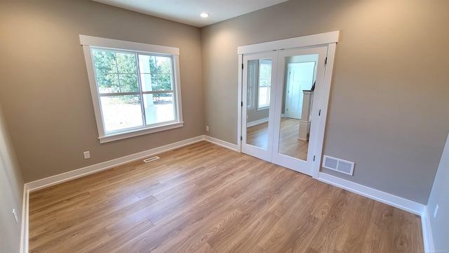 spare room featuring french doors and light wood-type flooring