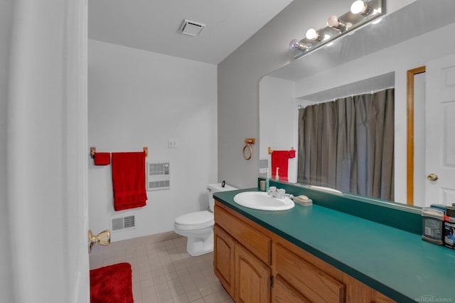 bathroom featuring vanity, heating unit, toilet, and tile patterned floors