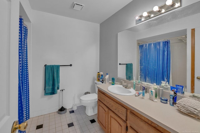 bathroom featuring tile patterned flooring, vanity, and toilet