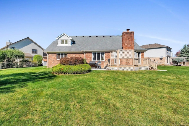 back of property with a yard and a wooden deck