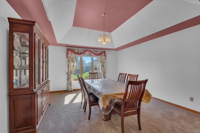 dining room featuring light colored carpet, an inviting chandelier, and a raised ceiling