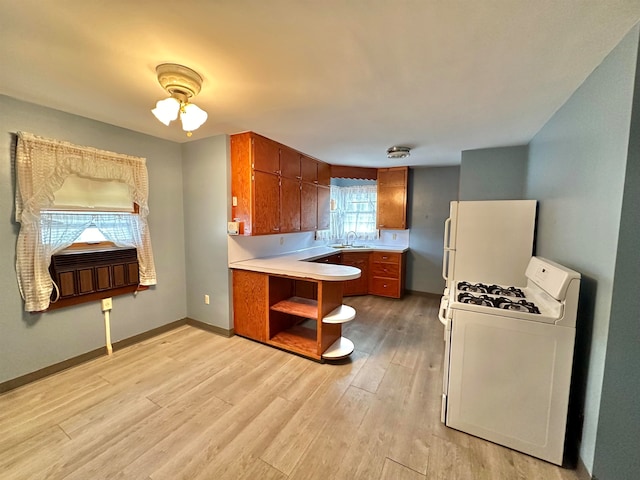 kitchen with sink, kitchen peninsula, light hardwood / wood-style floors, and white range with gas cooktop