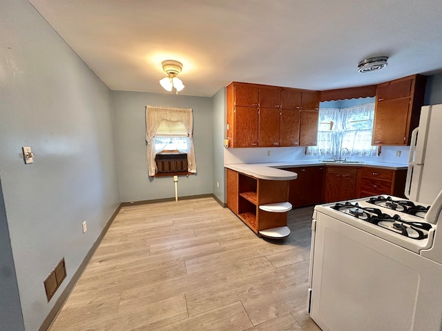 kitchen featuring white appliances, sink, and light wood-type flooring