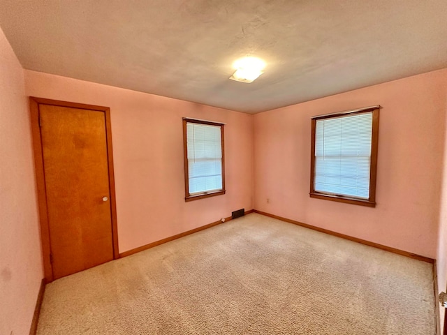 carpeted spare room featuring a textured ceiling