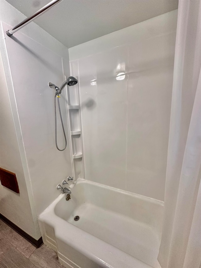 bathroom featuring wood-type flooring and shower / bath combo with shower curtain