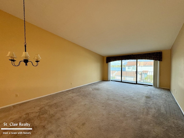 carpeted empty room with lofted ceiling and a chandelier