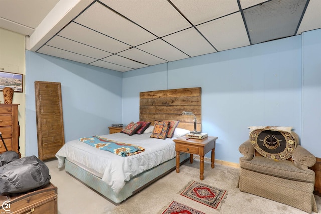 carpeted bedroom featuring a drop ceiling