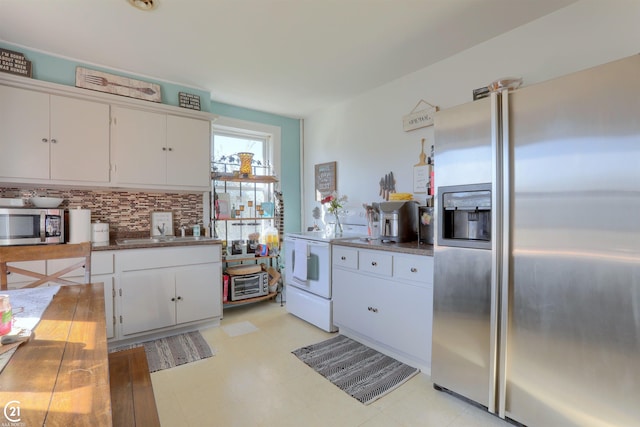 kitchen with appliances with stainless steel finishes, decorative backsplash, white cabinetry, and sink