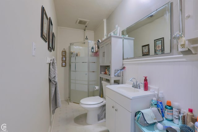 bathroom featuring toilet, vanity, and an enclosed shower