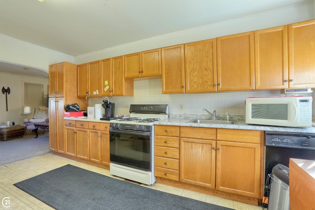 kitchen featuring white appliances, sink, and backsplash