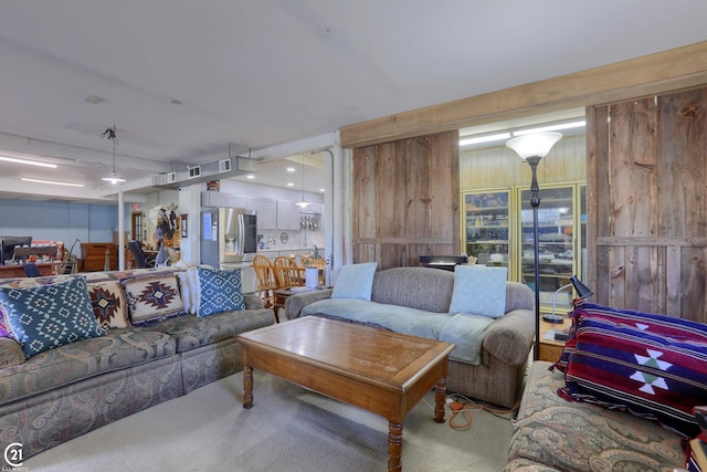 carpeted living room with wooden walls