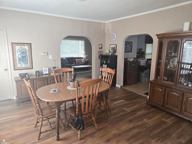 dining area with ornamental molding and dark hardwood / wood-style flooring