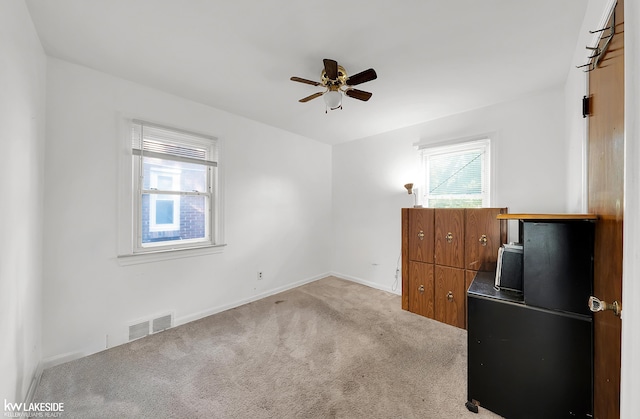 interior space featuring ceiling fan and light colored carpet