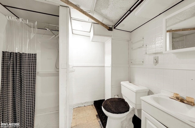 bathroom featuring vanity, tile walls, toilet, and a shower with shower curtain