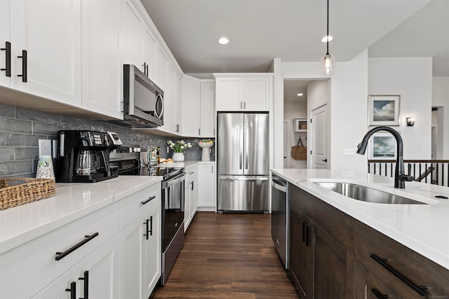 kitchen featuring tasteful backsplash, dark wood-type flooring, sink, stainless steel appliances, and white cabinetry