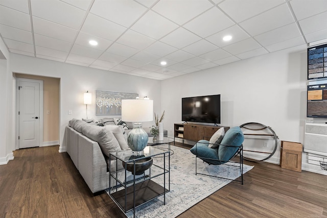 living room featuring dark hardwood / wood-style floors and a paneled ceiling