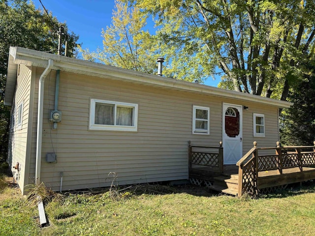 back of house featuring a yard and a wooden deck