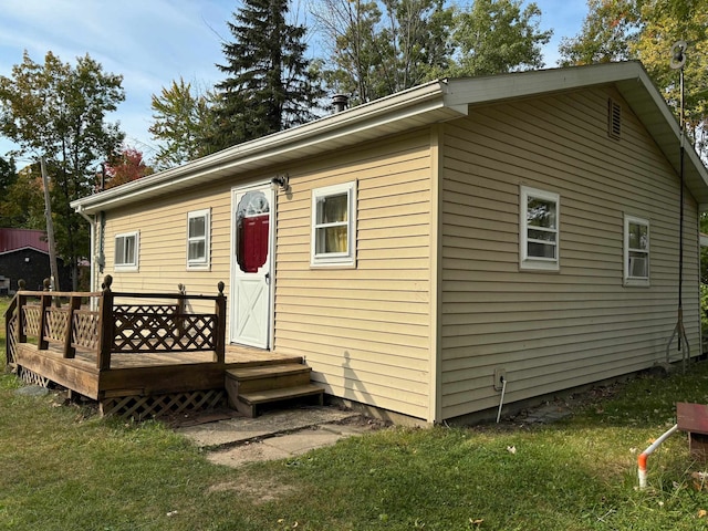 rear view of property with a yard and a wooden deck