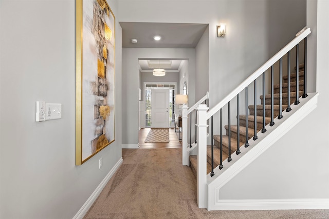 entrance foyer featuring crown molding and carpet flooring