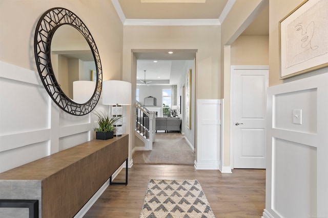 foyer featuring ornamental molding, hardwood / wood-style flooring, and ceiling fan