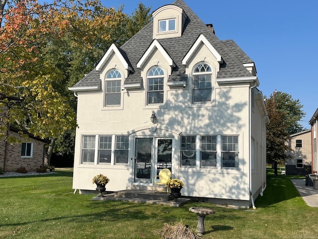 rear view of house featuring a lawn