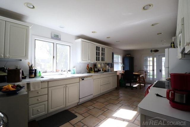 kitchen with white appliances, french doors, sink, and white cabinetry