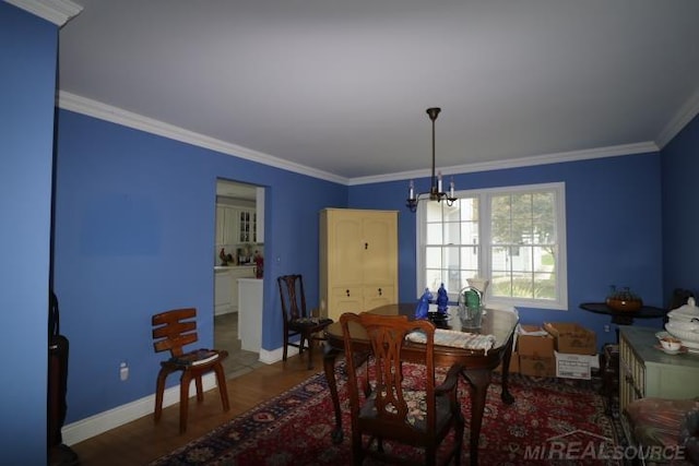 dining room with dark hardwood / wood-style floors, crown molding, and a notable chandelier